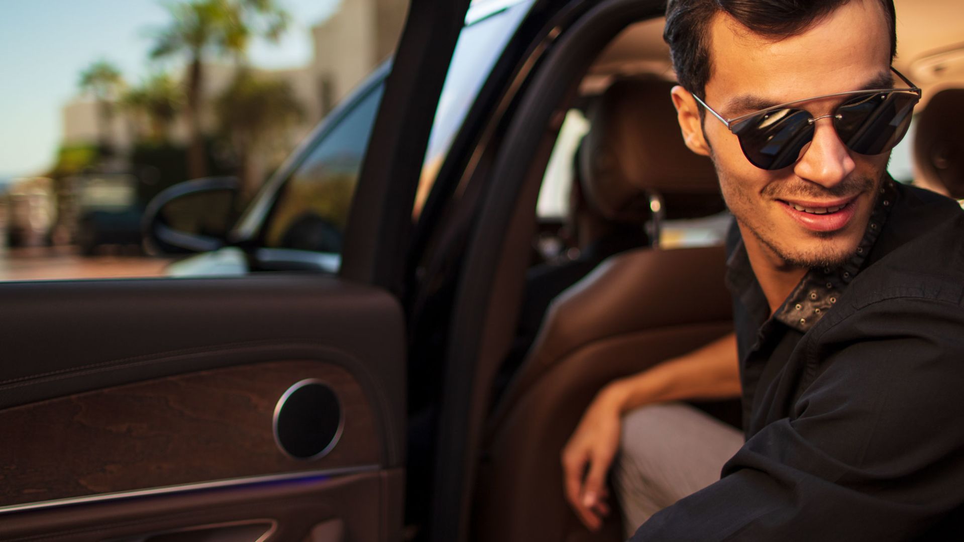 A Man Wearing Sunglasses Driving A Car