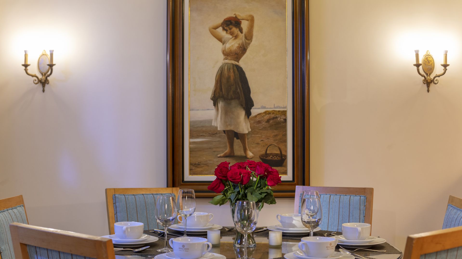 A Table With A Vase Of Flowers And A Painting On The Wall